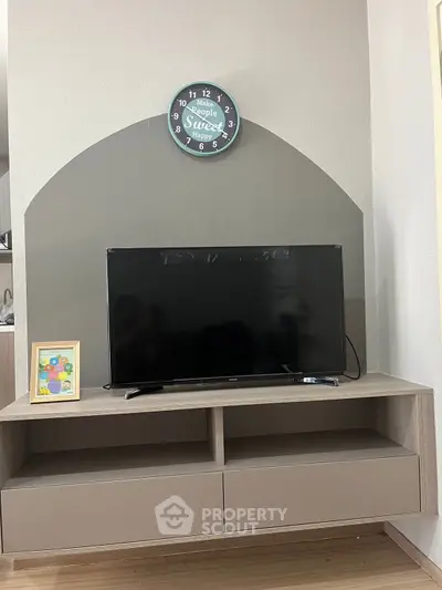 Modern living room with stylish TV stand and wall clock, perfect for cozy home entertainment.