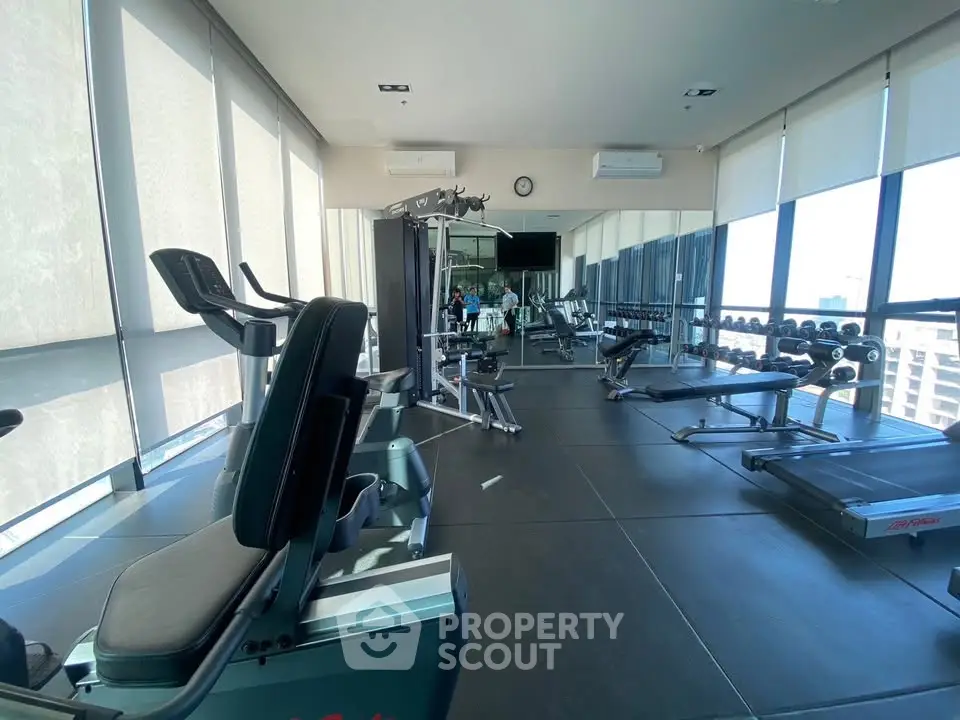 Modern gym with state-of-the-art equipment and panoramic city views, perfect for fitness enthusiasts.
