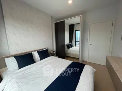 Modern bedroom with stylish decor and mirrored wardrobe in a cozy apartment.