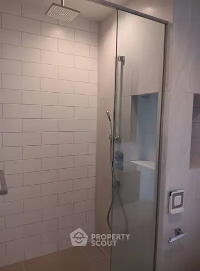 Modern bathroom with glass shower enclosure and sleek tile design.