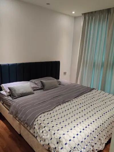 Cozy bedroom with elegant decor and soft lighting, featuring a comfortable bed and stylish curtains.