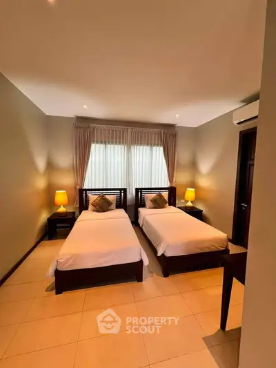 Spacious bedroom with twin beds and elegant decor in modern real estate property.