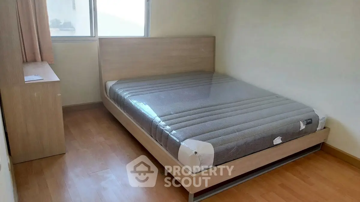 Cozy bedroom with new mattress and wooden furniture, perfect for restful nights.