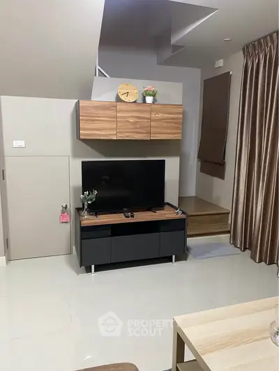 Modern living room with sleek TV setup and stylish wooden accents.