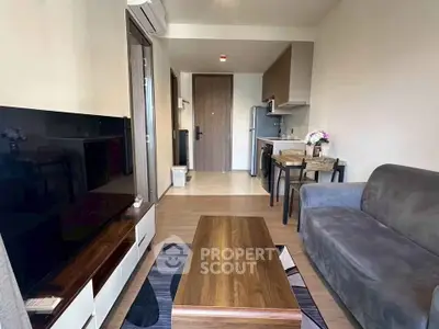 Modern living room with sleek furniture and open kitchen layout in a stylish apartment.