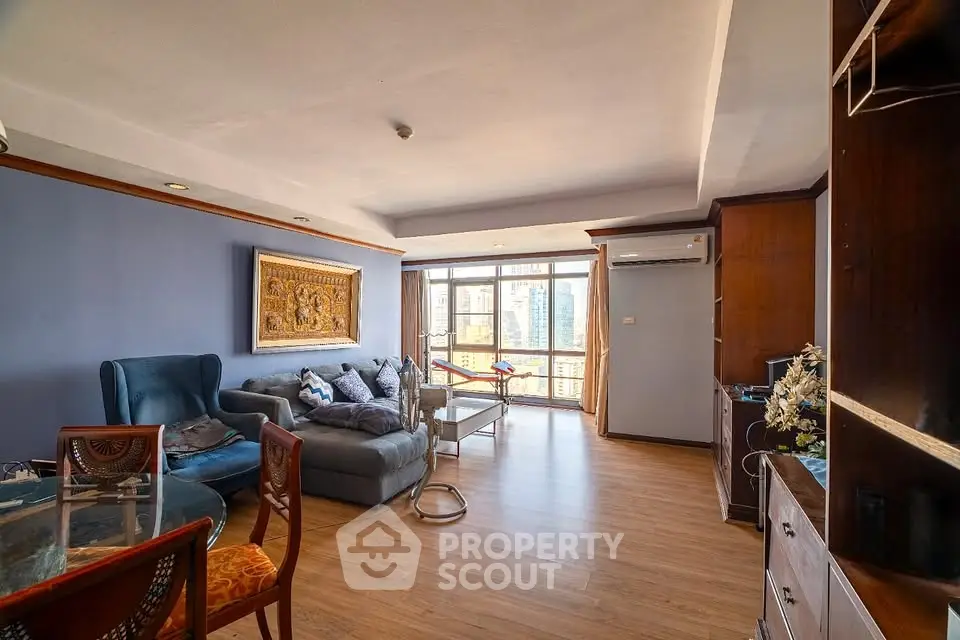 Spacious living room with elegant decor and city view, featuring cozy seating and natural light.