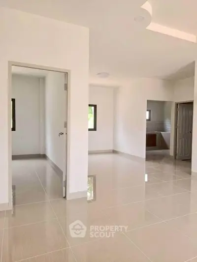 Spacious modern interior with glossy tiled floors and neutral walls, ideal for customization.
