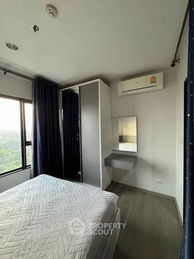 Modern bedroom with large window and air conditioning, featuring sleek wardrobe and cozy bed.