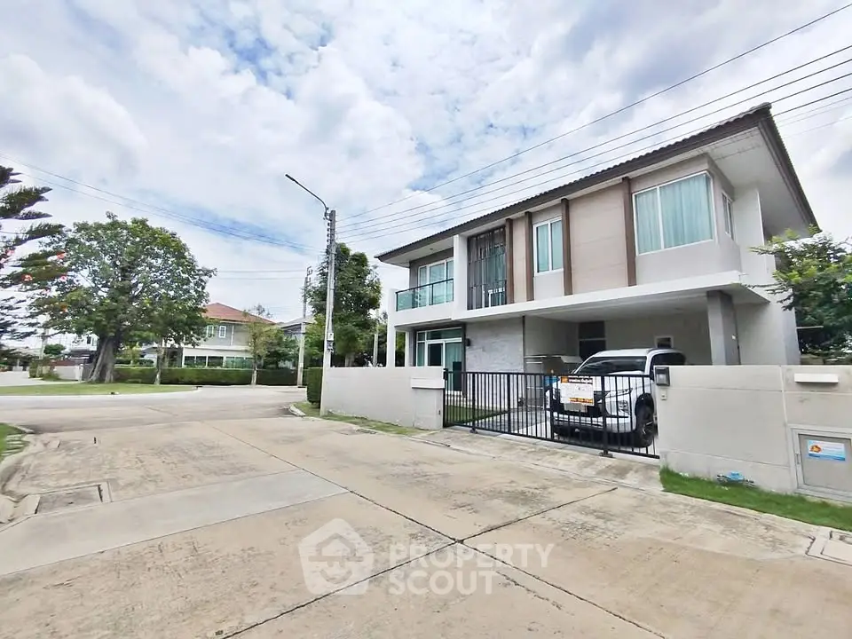 Modern two-story house with driveway and parked car in suburban neighborhood