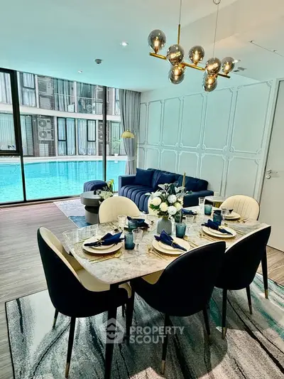 Luxurious living room with pool view, elegant dining setup, and modern decor in a high-end apartment.