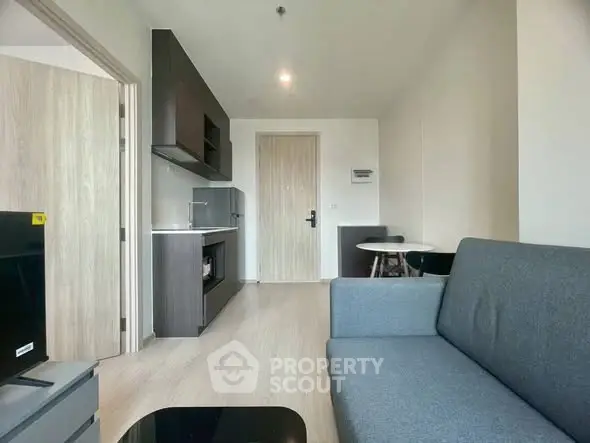 Modern living room with sleek furniture and open kitchen layout in a stylish apartment.