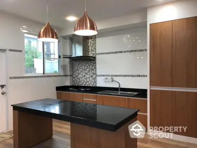 Modern kitchen with sleek black countertops and stylish pendant lighting