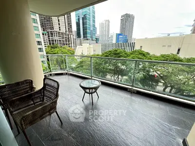 Spacious balcony with city view and modern glass railing, perfect for relaxation.