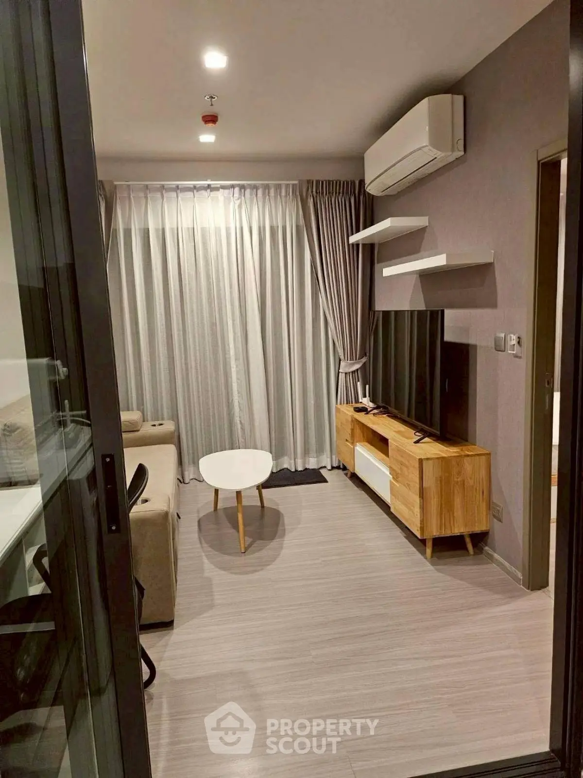 Modern living room with sleek furniture and air conditioning in a stylish apartment.