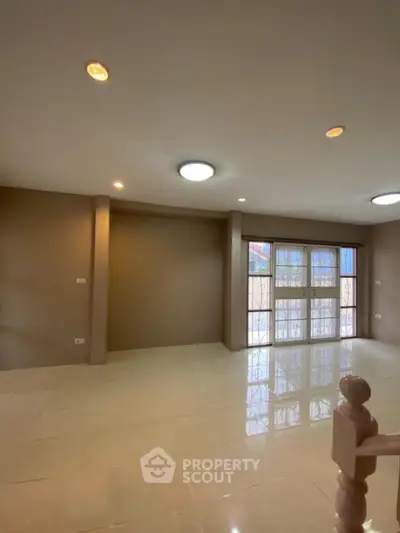 Spacious living room with large windows and neutral tones for modern comfort.