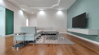 Spacious modern living room with sleek furniture and mounted TV, perfect for relaxation and entertainment.