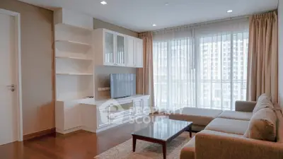 Spacious living room with modern furniture and large windows offering city views.