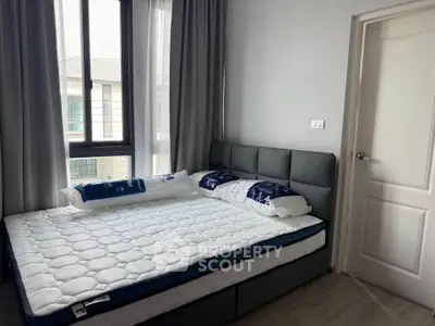 Cozy bedroom with modern decor and large window for natural light.