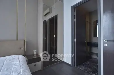 Modern bedroom with mirrored wardrobe and open door to bathroom