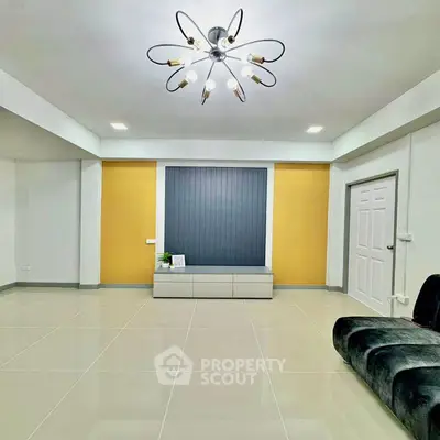 Modern living room with stylish chandelier and sleek tiled flooring