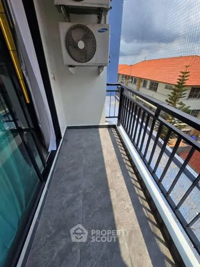 Charming balcony with modern railing and air conditioning unit, offering a cozy outdoor space with a view.