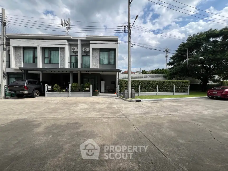 Modern townhouse with spacious driveway and lush greenery in a serene neighborhood.