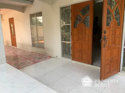 Charming entrance with elegant wooden doors and tiled flooring