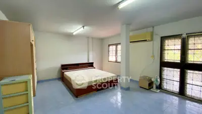 Spacious bedroom with large windows and modern furnishings for a comfortable living experience.
