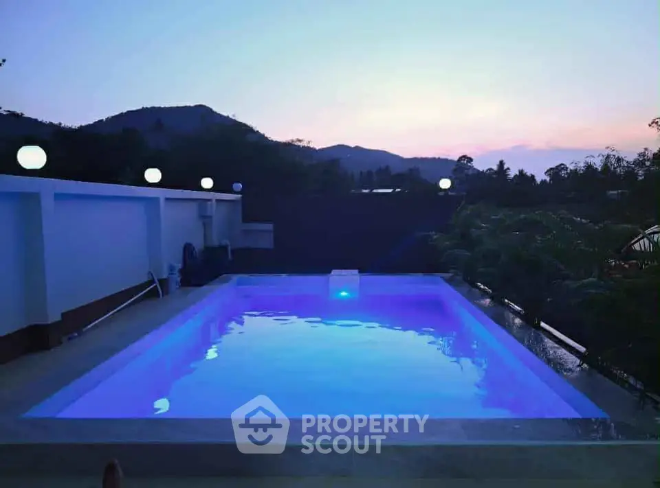 Stunning rooftop pool with scenic mountain views at sunset, perfect for relaxation and luxury living.