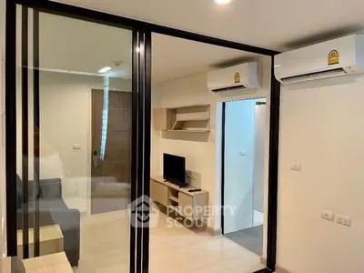 Modern apartment interior with glass partition and air conditioning units.
