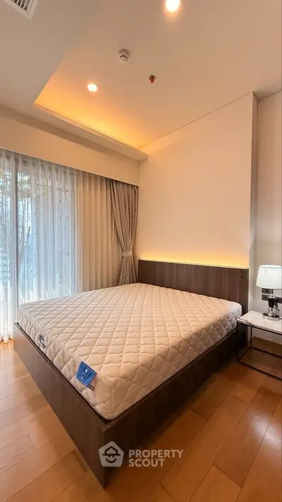 Spacious bedroom with modern design and large window for natural light.