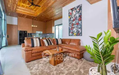 Luxurious living room with leather sofa, modern decor, and open kitchen layout in a stylish home.