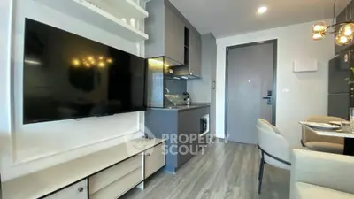 Modern living room with sleek kitchen and stylish decor in a contemporary apartment.