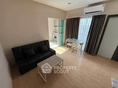 Modern living room with sleek furniture and natural light, featuring a compact dining area and air conditioning.