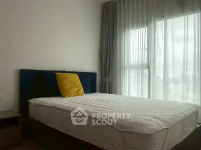 Cozy bedroom with large window and modern decor in urban apartment