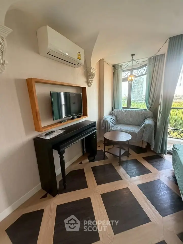 Charming living room with unique flooring and cozy seating area, featuring a wall-mounted TV and air conditioning.