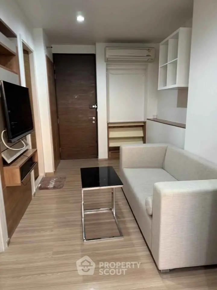 Modern living room with sleek design, featuring a cozy sofa and wall-mounted TV, perfect for urban living.