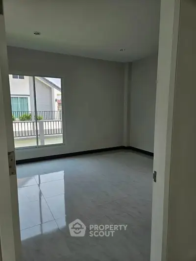 Spacious empty room with large window and glossy tiled floor, perfect for customization.