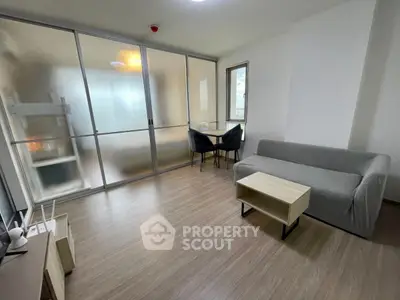 Modern living room with sleek furniture and glass partition, perfect for urban living.