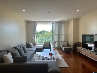 Spacious living room with modern furniture and large windows offering a serene view.