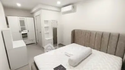 Modern bedroom with stylish furniture and air conditioning in a cozy apartment.