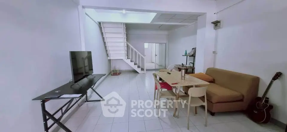 Spacious living room with modern furniture and staircase in minimalist home