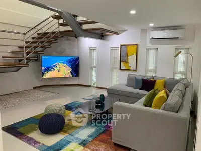 Modern living room with stylish staircase and colorful decor