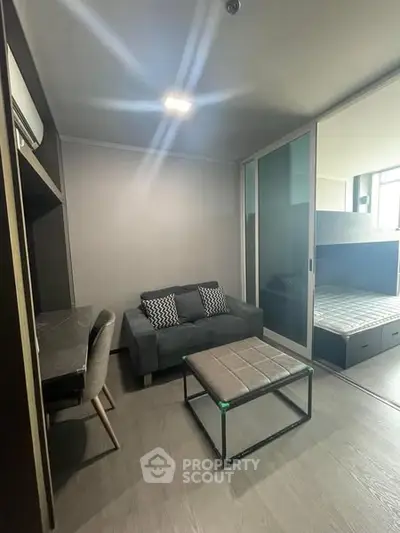 Modern compact living room with sofa and study area in stylish apartment