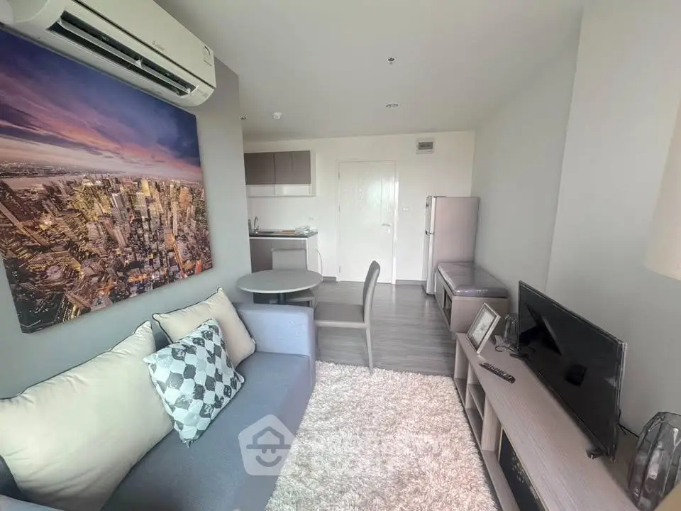 Modern living room with cozy seating, stylish decor, and compact kitchen area in open layout apartment.