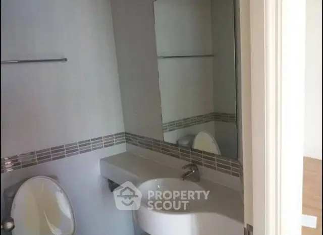 Modern bathroom with sleek sink and large mirror in a stylish apartment.
