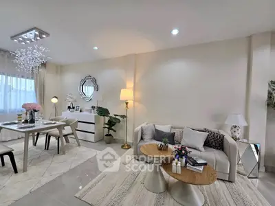 Elegant living room with modern decor and dining area, featuring stylish furniture and soft lighting.