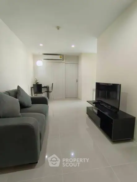 Modern living room with sleek furniture and minimalist design, featuring a comfortable sofa and flat-screen TV.