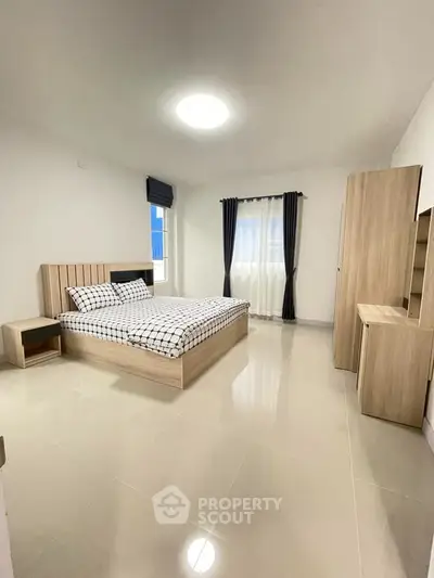 Spacious modern bedroom with stylish furniture and natural light