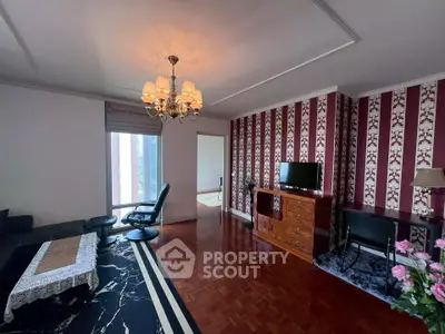 Elegant living room with stylish decor and parquet flooring, featuring a cozy seating area and modern entertainment setup.